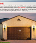 Image of a garage door with two Dusk To Dawn Sensor Outdoor Wall Lanterns With Built In GFCI Outlet mounted on either side, noted with a 10ft separation required for proper function of the dusk to dawn sensor.