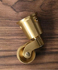 Built Tough Heavy Duty Antique Casters Featuring Sweet Smooth Gliding Solid Brass Wheels And Rock Solid Double Bearings For Easy Furniture Rolling And Zero Floor Scratches, shown from the side on wooden surface.