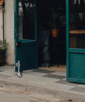 Heavy Duty Shock Absorbing Gate Caster Built Tough For Smooth Omnidirectional Rolling On Rough Terrain And Simple Swap Replacement Hardware That Lasts A Long Time visible on a green door at a cafe entrance.