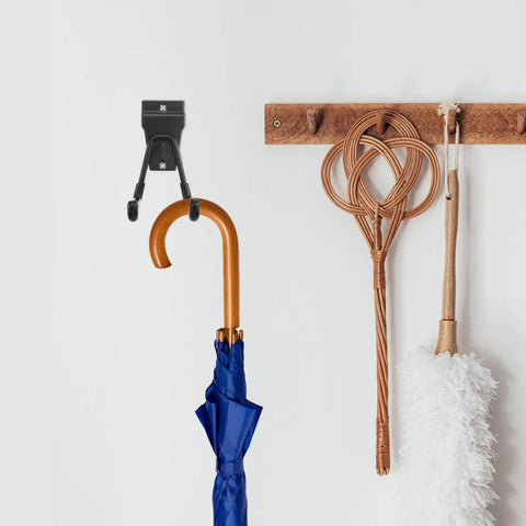 Rock Solid Black Metal Wall Hooks For Bags And Hats With Heavy Duty Mount displaying a blue umbrella on a white wall.