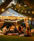 LED Outdoor String Lights 109 Ft With 52 Edison Shatterproof Bulbs Plus 2 Spares hanging over a backyard gathering at dusk