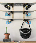 Handcrafted Natural Wood Wall Mount Skateboard Rack Holds Three Longboards And Snowboards Featuring Protective Cushioned Sleeves, displaying skateboards and helmet.