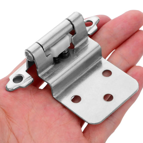 Close-up of a hand holding a single hinge from the 8 Pack Self Closing Flush Mount Cabinet Hinges With Door Bumpers Concealed Hardware