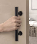 Hand holding Matte Black Barn Door Pull And Flush Mounted Handle Set For Sliding Interior Doors Includes Hardware One Pack