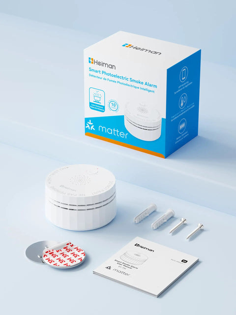 Hella Smart Smoke Detector With Matter Thread Protocol Integrated Temp And Humidity Gauge Plays Nice With Alexa Google Home And SmartThings on a blue background with packaging and installation tools.