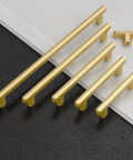 Top Shelf 10 Pack Brushed Gold Cabinet Pulls 5 Inch 128 mm Spacing kitchen drawer handles, showcasing varying lengths on a countertop.