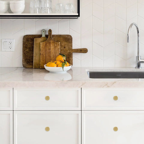 10 Pack Brushed Brass Kitchen Cabinet Knobs with Knurled Texture installed on white drawers in a modern kitchen setting.