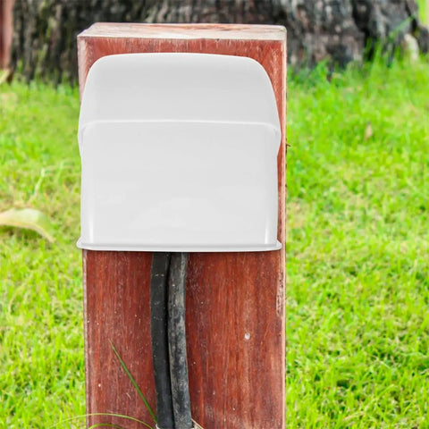 2 Piece Weatherproof Outlet Boxes Tough As Nails ABS Wall Plug Covers Socket Rain Shield mounted on a wooden post outdoors.