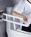Built Tough Twenty Eight Inch Flip Up Toilet Grab Bar With Rock Solid Stainless Core And No Slip Abs Handle For Wall Mount Bathroom Setup Easy Secure Install For Seniors Or Post Surgery Recovery White, in use beside toilet.