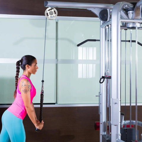 Woman using Heavy Duty Replaceable Cable Pulley Wheels 10 Pack Smooth As Butter Aluminum Alloy Lifting Blocks in gym.
