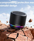 Compact Bluetooth Speaker With 12 Hour Battery Life, Noise Reduction Microphone, Metal Shell, RGB Lights, placed on rocks.