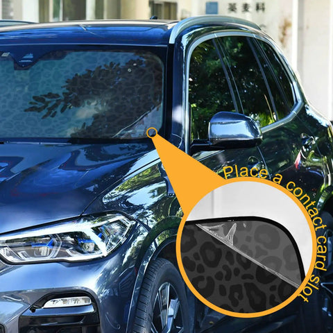 Leopard Print Car Windshield Sun Shade Foldable UV Ray Sun Visor Keeps Your Ride Cool With Four Suction Cups Animal Skin Pattern Fits Most Vehicles 51 By 27.6 Inches on a parked blue car highlighting contact card slot feature.
