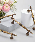 Solid Antique Brass Cabinet Pulls 5 Inch Drawer Handles 5 Pack Vintage Zinc Alloy Furniture Hardware on display with flowers.