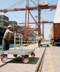 Workers pushing platform trucks on Heavy Duty 6X2 Inch Caster Set Of 4 With Polyurethane Treads And Cast Iron Cores, 5000 lb Capacity