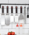 28 Piece Griddle Gear Kit For Blackstone Flat Top Grill Spatulas Scraper Turners hanging with squeeze bottles in kitchen setting.