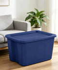 Built Tough 18 Gallon Blue Plastic Storage Tote Bin Featuring A Secure Snap On Lid For Zero Hassle Home Organization And Reliable Gear Storage Year Round beside a sofa in a living room.