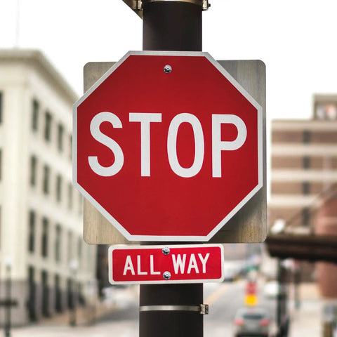 Stop sign with red background and white letters, featuring an all-way sign beneath for traffic control.