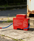 Heavy Duty Automatic Engine Fire Suppressor Self Activating 30g Aerosol Extinguisher With Thermal Trigger in red on pavement.