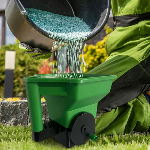 Person using Precision Handheld Lawn And Yard Spreader With Crank Handle Anti Clog Hopper for even fertilizer spread on grass.