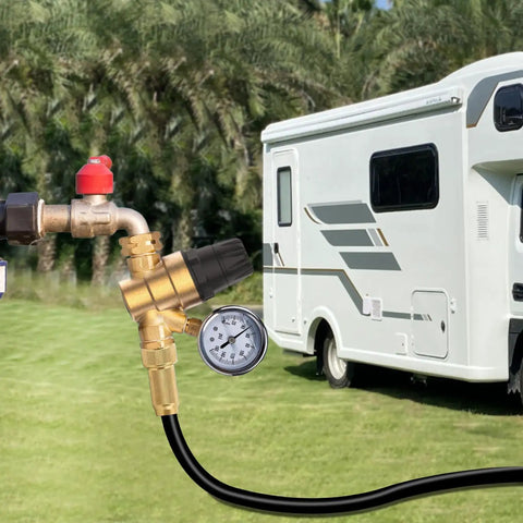 Solid Brass RV Water Pressure Regulator With Built In Gauge And Adjustable Valve connected to an RV in a grassy area.