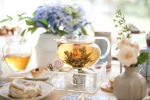 Kyoto 2-In-1 Tea Kettle And Tea Maker Glass Teapot With Removable Loose-Leaf Infuser brewing blooming tea on a table setting.