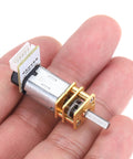 Close-up of Two Pack 500 RPM Micro Gear Motors With Encoder Six Volt N20 Gearbox High Torque Reduction Motors displayed in hand.