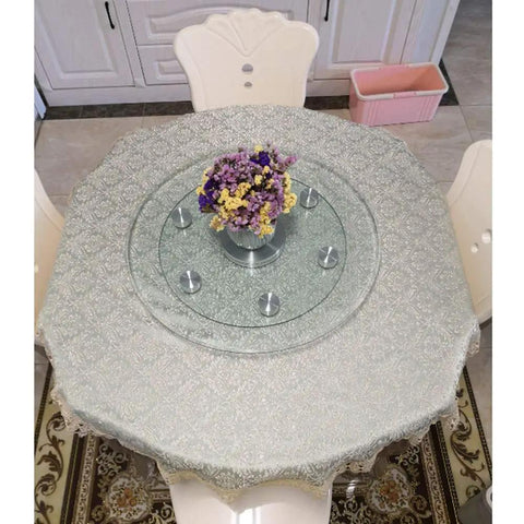 Thickened 12mm Tempered Glass Lazy Susan Turntable on a dining table with flowers, providing a smooth swivel action.