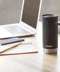 Lockdown Seal Double Wall Vacuum Insulated Stainless Steel Travel Mug Keeps Your Brew Piping Hot Six Hours And Ice Cold Twelve Hours For Daily Grinds 16 Oz Licorice on a desk with a laptop, phone, and notebook.