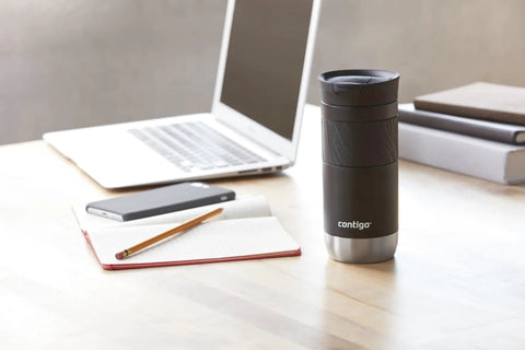 Lockdown Seal Double Wall Vacuum Insulated Stainless Steel Travel Mug Keeps Your Brew Piping Hot Six Hours And Ice Cold Twelve Hours For Daily Grinds 16 Oz Licorice on a desk with a laptop, phone, and notebook.