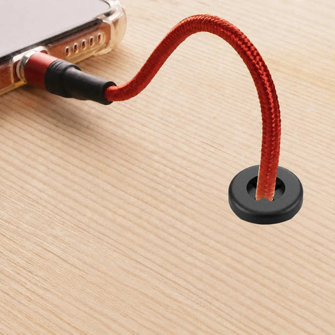 Hella Durable Rubber Cable Grommets 12 Piece Pack Clean Work Desk Cable Management Kit 1 2 Inch Flexible Wire Hole Covers No Snag Desk Patch Black showing black grommet with red wire on wood desk.