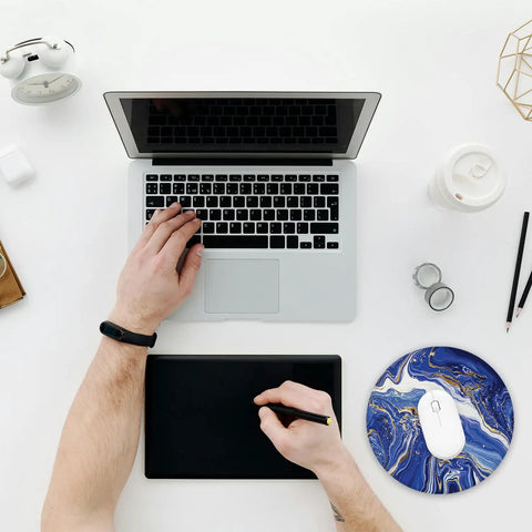 Top view of workspace with laptop, drawing tablet, and Luxury Blue Gold Marble Round Mouse Pad With Non Slip Rubber Base And Stitched Edge.