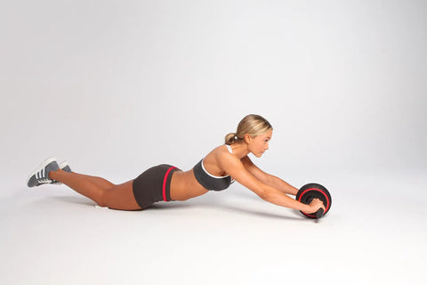Killer Ab Rocker And Complete Core Toning Setup Featuring Rock Solid Ergonomic Handles in use by a woman with an ab roller.