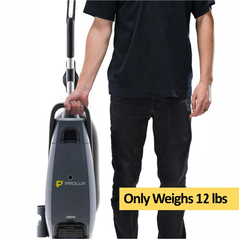 Prolux Phantom Pro Commercial Upright Vacuum With HEPA Filtration And Bagged Design Offering High Suction Power For Deep Cleaning being held by a person, weighing only 12 lbs.