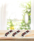 12 Pack Rock Solid Sliding Door And Window Sash Pulleys Featuring Double Wheel Rollers on wooden table with outdoor backdrop.