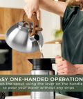 Person pouring water from Stovetop Whistling Tea Kettle Two Point Four Quart Stainless Steel For Induction And Gas Stovetops Durable Rust Resistant Teapot That Heats Fast And Boils Tea In Minutes into a cup with easy one-handed operation