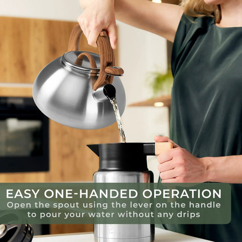 Person pouring water from Stovetop Whistling Tea Kettle Two Point Four Quart Stainless Steel For Induction And Gas Stovetops Durable Rust Resistant Teapot That Heats Fast And Boils Tea In Minutes into a cup with easy one-handed operation