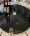 Heavy Duty Tempered Glass Lazy Susan Rolls Smooth With 360 Swivel, Giant Round Turntable Plate reflecting wine bottles and glasses on a dining table.