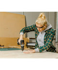 Woman using Compact 1/2 Inch 20V Cordless Drill Driver Featuring Brushless Motor And Adjustable Torque Settings on wood.