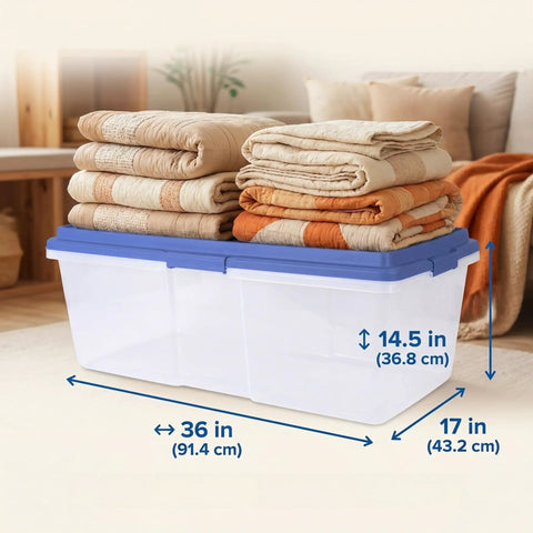 Straight Up Heavy Duty 113 Qt Long Storage Bin With Secure Snap On Lid, Crystal Clear Stackable Plastic Tote For Bulky Blankets And Seasonal Gear, Rock Solid Zero Fuss Garage Organizer stacked with folded blankets.