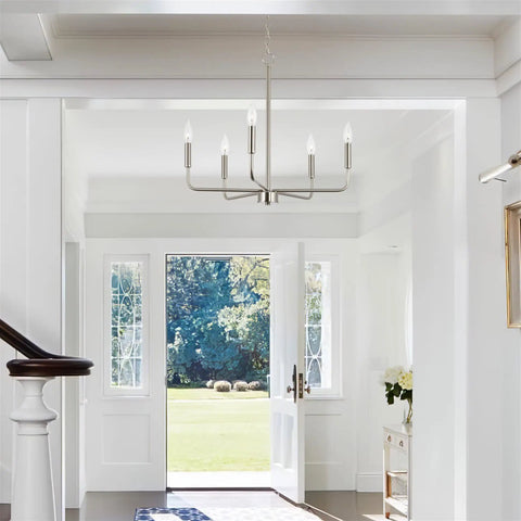 Camille 22 Inch Modern 5-Light Candle Style Chandelier With Open Frame In Brushed Nickel Finish hanging in a bright entryway.