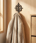 Rock Solid Cast Iron Wall Hook Knockout Vintage Charm For Entryway And Master Bedroom Bullet Proof Heavy Duty Towel And Coat Rack hanging a coat on a wooden wall.