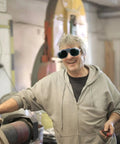 Two Piece Electric Welding Glasses And Tough As Nails Safety Goggles Featuring A Scratch Resistant Coating Made For Serious Welders Who Want Anti UV Shielding And Zero Glare Distractions That Stay Crystal Clear All Day Long worn by smiling man in workshop.