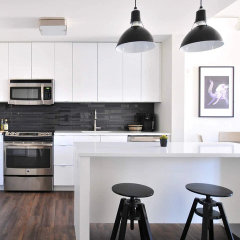 Modern kitchen with dark pendant lights, white cabinetry, and A19 Led Light Bulbs 9W, 60W Equivalent, E26 Base, Daylight White 5000K.