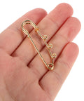 Must Have Set Of Twenty Super Tough Golden Loop Safety Pins To Quick Fix Denim And Anchor Heavy Skirts While Halting Embarrassing Wardrobe Malfunctions Daily in a hand.
