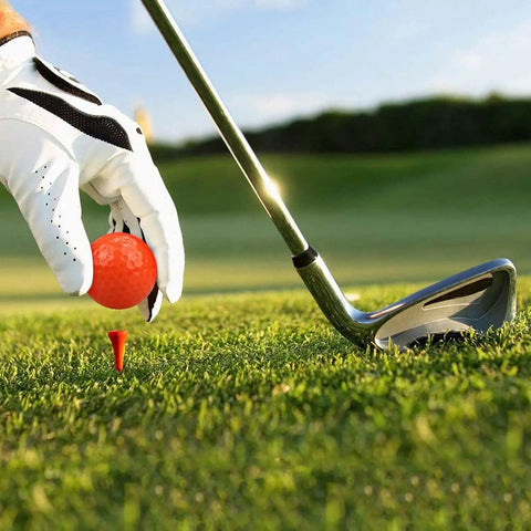 Golfer placing a bright colored mini golf ball on a tee for practice and fun with high visibility for easy tracking outdoors