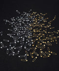 Kickass Assorted Steel Safety Pins Bulk Kit For Sewing Tailoring And Crafting with silver and gold safety pins on a black background.