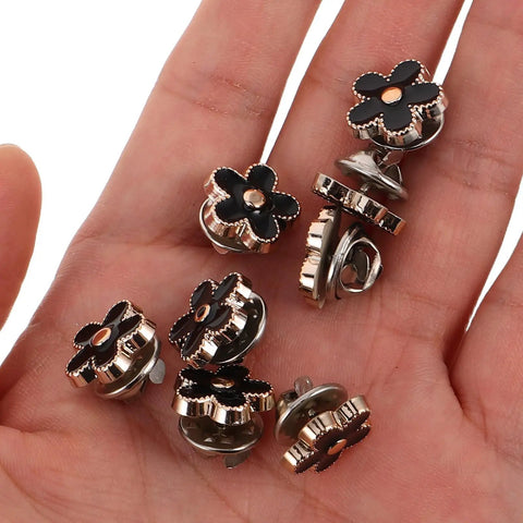 Twenty Piece Black Flower Snap Buttons Slick Metal Clip On Fasteners For Apparel Repairs displayed in hand, featuring black flower design.