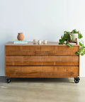 Wooden dresser on casters with a plant on top, featuring Three Inch Plate Caster Wheel Set With Cast Iron Swivel Plate Casters And Dual Locking.