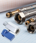 Slick Brass Mini Ball Valve With Npt One Quarter Inch Threaded Ends positioned with plumbing connectors on grid paper.