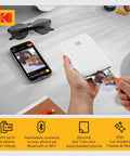 Person using Step Instant Smartphone Photo Printer On The Go Portable Mini Color Wireless Printer For iOS And Android Bluetooth Printing From Your Phone With Zink 2x3 Sticky Back Photos And Free Editing App White.